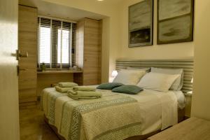 a bedroom with a bed with towels on it at Filia Luxury Apartments in Chania Town
