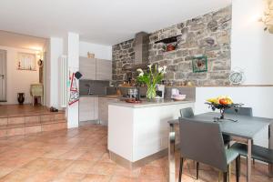 a kitchen with a table and a stone wall at Romantic Home - Lake Como in Nesso