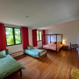 a bedroom with two beds and red curtains at Vallombre natiora 