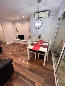 a dining room with a table and chairs and a television at Ca la Noa in Viladecáns