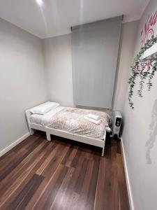 a small bedroom with a bed and wooden floors at Ca la Noa in Viladecáns