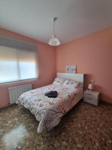 1 dormitorio con 1 cama en una habitación rosa en Casa Conce, en Riópar