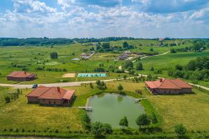an aerial view of a farm with a pond at Prie Trakų in Petkėniškės