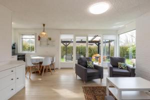 una cucina e un soggiorno con tavolo e sedie di Welcome in - Koekoeksbloemwei 90, Kortgene a Kortgene