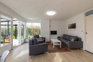 un soggiorno con due divani e una TV di Welcome in - Koekoeksbloemwei 90, Kortgene a Kortgene