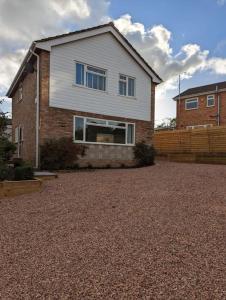 a house sitting on top of a gravel driveway at Cosy 4 Bedroom Town House Ample Parking & Netflix in Leominster