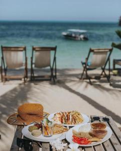 una mesa con dos platos de comida en la playa en Blue Oyster Hotel, en Jambiani