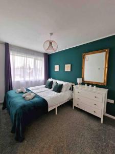 a bedroom with a bed and a mirror and a dresser at Stunning Gem detached with drive in High Hazels