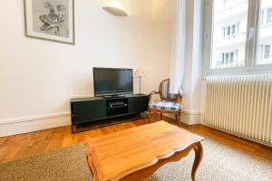 uma sala de estar com uma televisão e uma mesa de centro em The Urban Casimir #FG em Grenoble