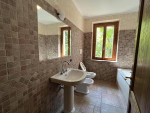uma casa de banho com um lavatório, um WC e um espelho. em Il borgo fra i laghi em Monzambano
