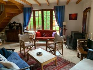 ein Wohnzimmer mit einem Sofa und Stühlen in der Unterkunft La Villa Flore in Saint-Jouin-Bruneval