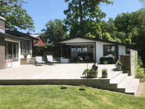 a large patio with chairs and a house at Nice holiday home in Tallbacken outside Ljungby in Bolmstad
