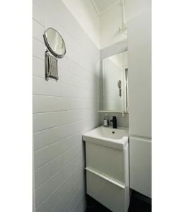 a white bathroom with a sink and a mirror at ApartmentInCopenhagen Apartment 298 in Copenhagen