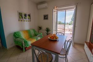 ein Wohnzimmer mit einem Tisch und einem Sofa in der Unterkunft Villa Tigani in Soverato Marina