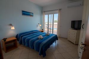 una camera con letto, televisore e finestra di Villa Tigani a Soverato Marina