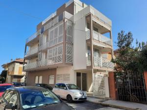 a apartment building with cars parked in front of it at Il Tucano Toco in Civitanova Marche
