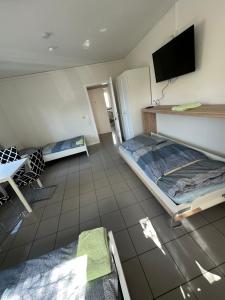 ヘスバッハにあるGästezimmer - Elbertのベッド1台と壁掛けテレビが備わる客室です。