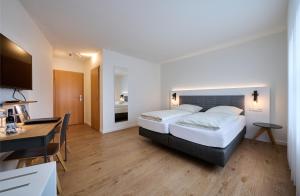 Habitación de hotel con 2 camas y escritorio en Hotel & Gasthaus Nagel, en Südlohn