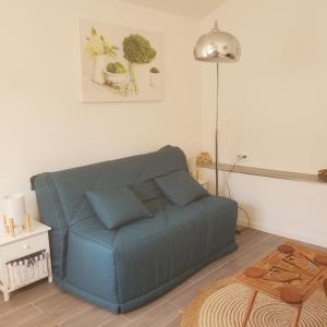 - un canapé bleu dans le salon dans l'établissement Madinina, à Bormes-les-Mimosas