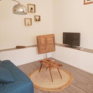 - un salon avec un canapé bleu et un tabouret en bois dans l'établissement Madinina, à Bormes-les-Mimosas