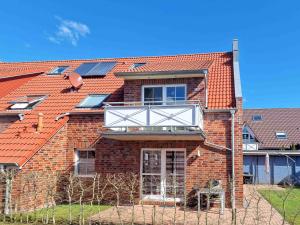 a brick house with solar panels on the roof at Herings Kajüte in Greetsiel