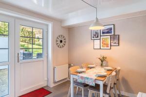 a dining room with a table and chairs and a clock at Ferienwohnung Dusamos in Bühlertal