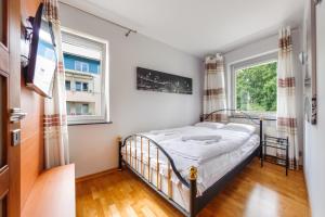 Schlafzimmer mit einem Bett und einem Fenster in der Unterkunft Apartamenty Sun & Snow Maria Ludwika in Sopot