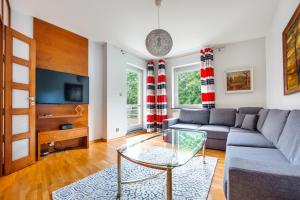 a living room with a couch and a glass table at Apartamenty Sun & Snow Maria Ludwika in Sopot