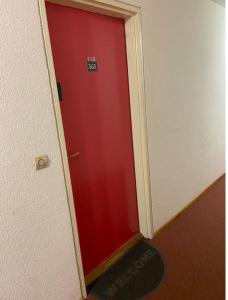 Una puerta roja en un pasillo con un cartel. en Studio 4 personnes - accès direct remontées mécaniques, en Les Contamines-Montjoie
