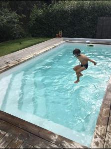 una joven en una piscina en el agua en Maison à Tosse avec vue sur la nature, en Tosse