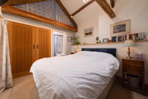 ein Schlafzimmer mit einem großen weißen Bett in einem Zimmer in der Unterkunft Rosehill Barn -a tranquil rural barn conversion in Barnstaple