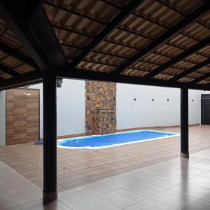 Casa de lazer km eventos في أوبيرابا: مسبح كبير في غرفة مع أرضية خشبية