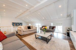 a living room with two couches and a table at Queensgate Court in London