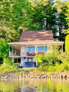 une maison sur la rive d'une masse d'eau dans l'établissement L'Oasis, à Ascot Corner