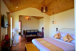 a bedroom with a large bed and a living room at Aaroham By Aamod Luxury Cottage Resort in Dalhousie