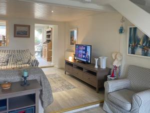 uma sala de estar com uma cama e uma televisão em Cottage 170 - Roundstone em Roundstone
