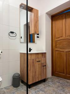 a bathroom with a sink and a wooden door at Dwór Jeziory Wielkie 