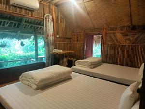 Pu LuongにあるPuluong homestay1holidayの木造キャビン内のベッド2台が備わる部屋
