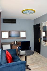 palmiye suıt otel في إسطنبول: غرفة معيشة مع أريكة زرقاء وطاولة