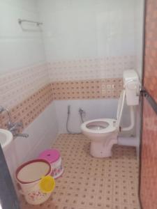 a bathroom with a toilet and a sink at Advait Holiday Home in Nagaon