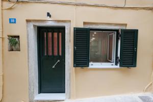 a green door and window on the side of a building at Casa Lefteritsa in Corfu