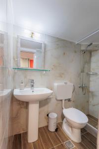 a bathroom with a sink and a toilet and a mirror at Casa Lefteritsa in Corfu