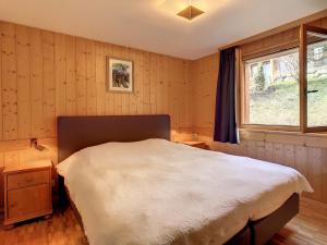 una camera con un grande letto e una finestra di Romarin 116 a Verbier