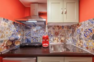 a kitchen with a sink and a red appliance on a counter at Casa Lefteritsa in Corfu