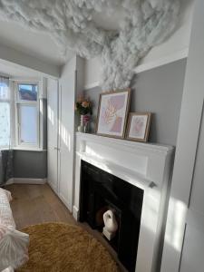 uma sala de estar com lareira e tecto de fumo em Comfortable 3 Bedroom House with Garden and Parking – Sleeps up to 6 em Catford