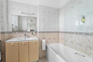 a bathroom with a tub and a sink and a mirror at Marine Hotel in Paignton