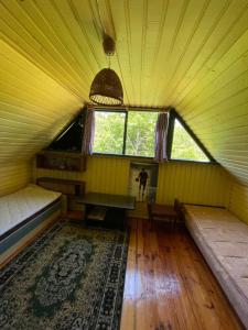 an attic room with two beds and a window at Summerhouse Labanoras in Stirniai