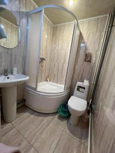 La salle de bains est pourvue d'une baignoire, de toilettes et d'un lavabo. dans l'établissement Комната Gold Rose, à Chişinău