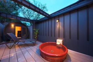 bañera en una terraza con silla en Meitei no Yado Hotel Koshien en Fuefuki