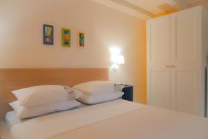 a bedroom with a bed with white sheets and pillows at Apartments Galatea with garage parking in Opatija